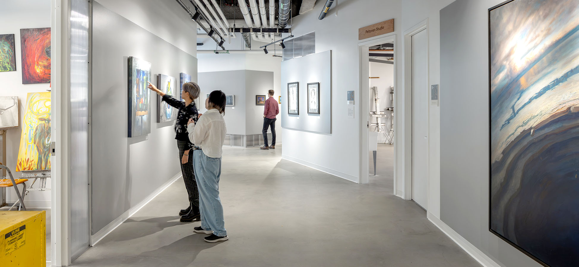 people looking at paintings on wall