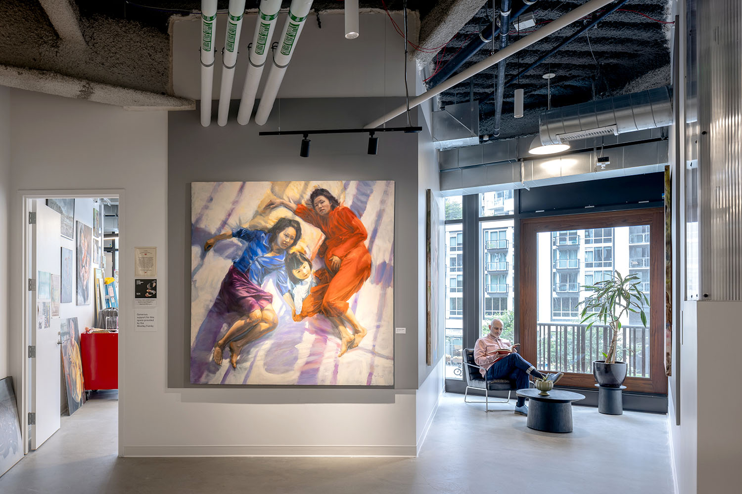 large painting and man sitting in chair