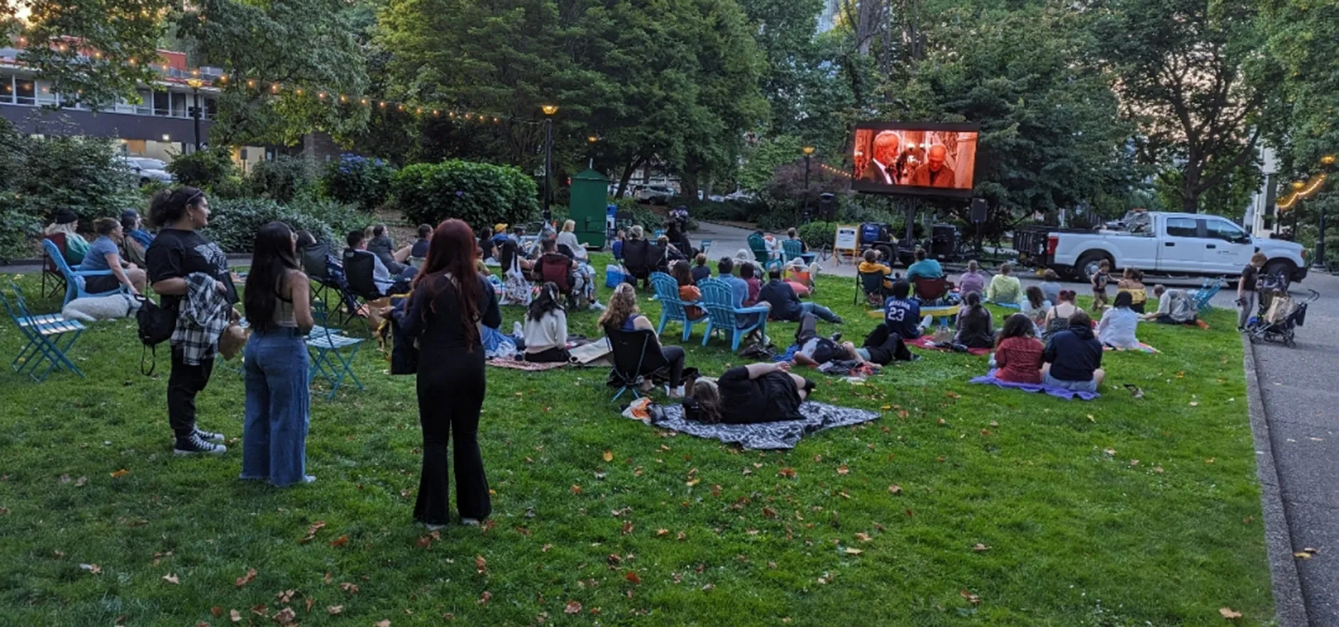 people on lawn watching outdoor movie