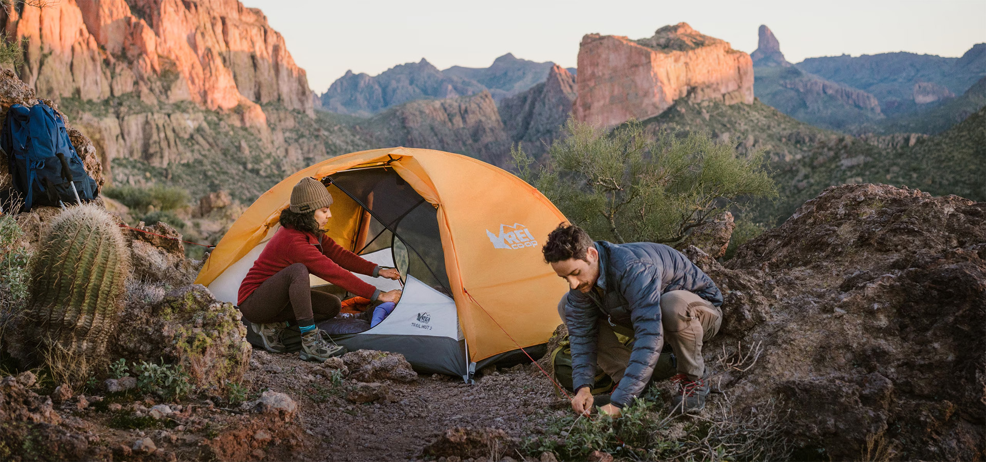 man & woman setting up tent in desert