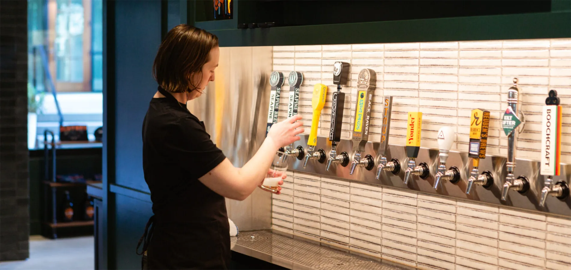 person pouring beer from tap