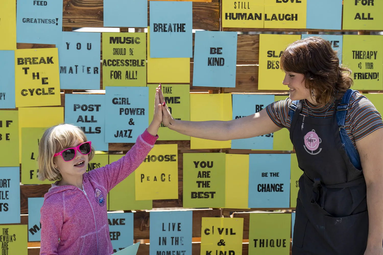 woman and child with wall of letterpress prints