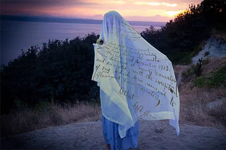 person draped in cloth with writing